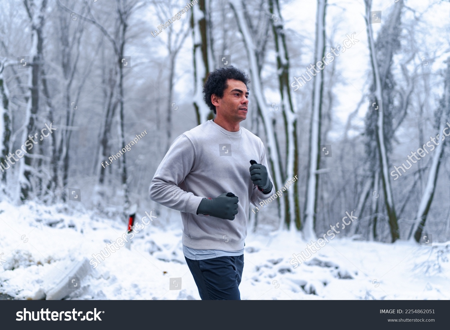 Man jogging in winter, surrounded by nature covered in snow. #2254862051