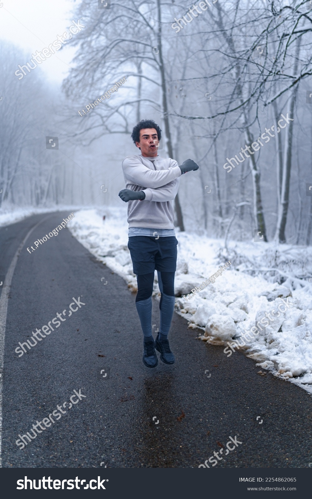 Warm up before going on a run in the foods on a snowy winter day, trees and ground are cover in snow #2254862065