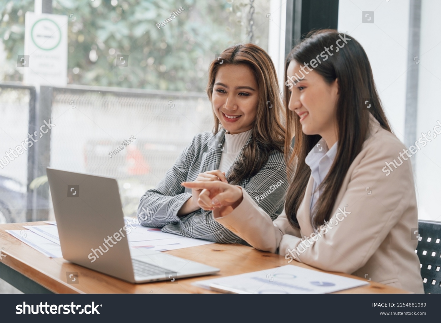 Two young pretty asia business woman in suit talking together in modern office workplace, Thai woman, southeast asian #2254881089