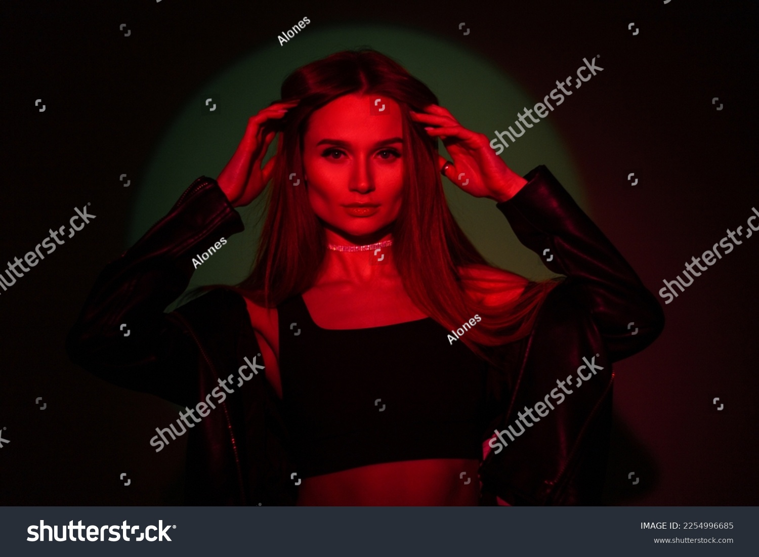 Fashionable beautiful creative woman in colored red light on a dark background with green #2254996685