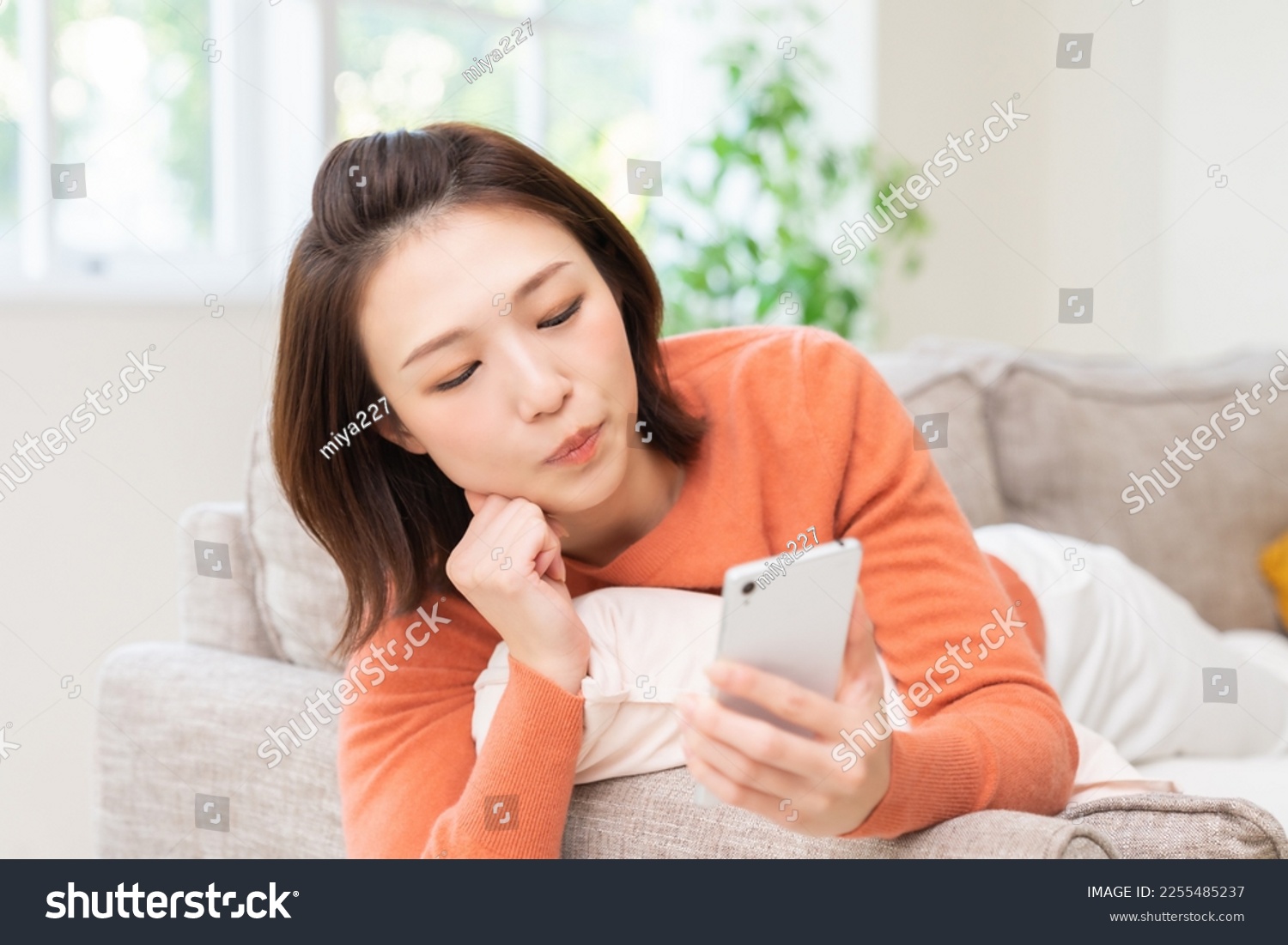 Young attractive Asian woman using a smartphone,think, #2255485237
