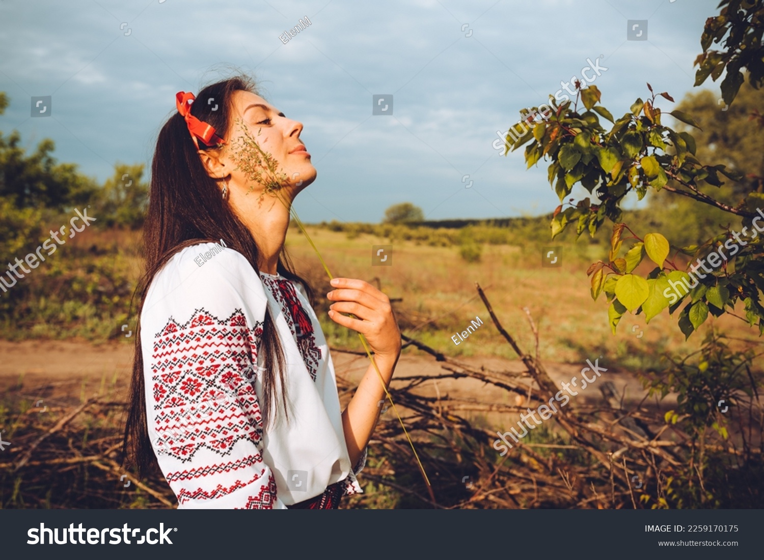 Photo of a smiling young woman in ethnic ukrainian shirt, enjoying the beautiful and peaceful weekend getaway #2259170175