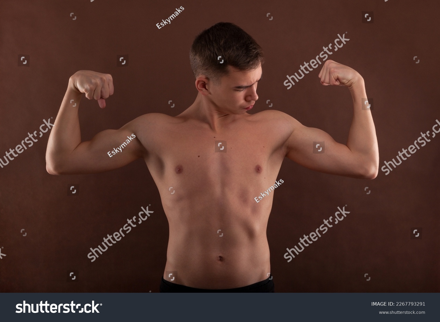 Handsome muscular shirtless adolescent boy flexing muscles. #2267793291