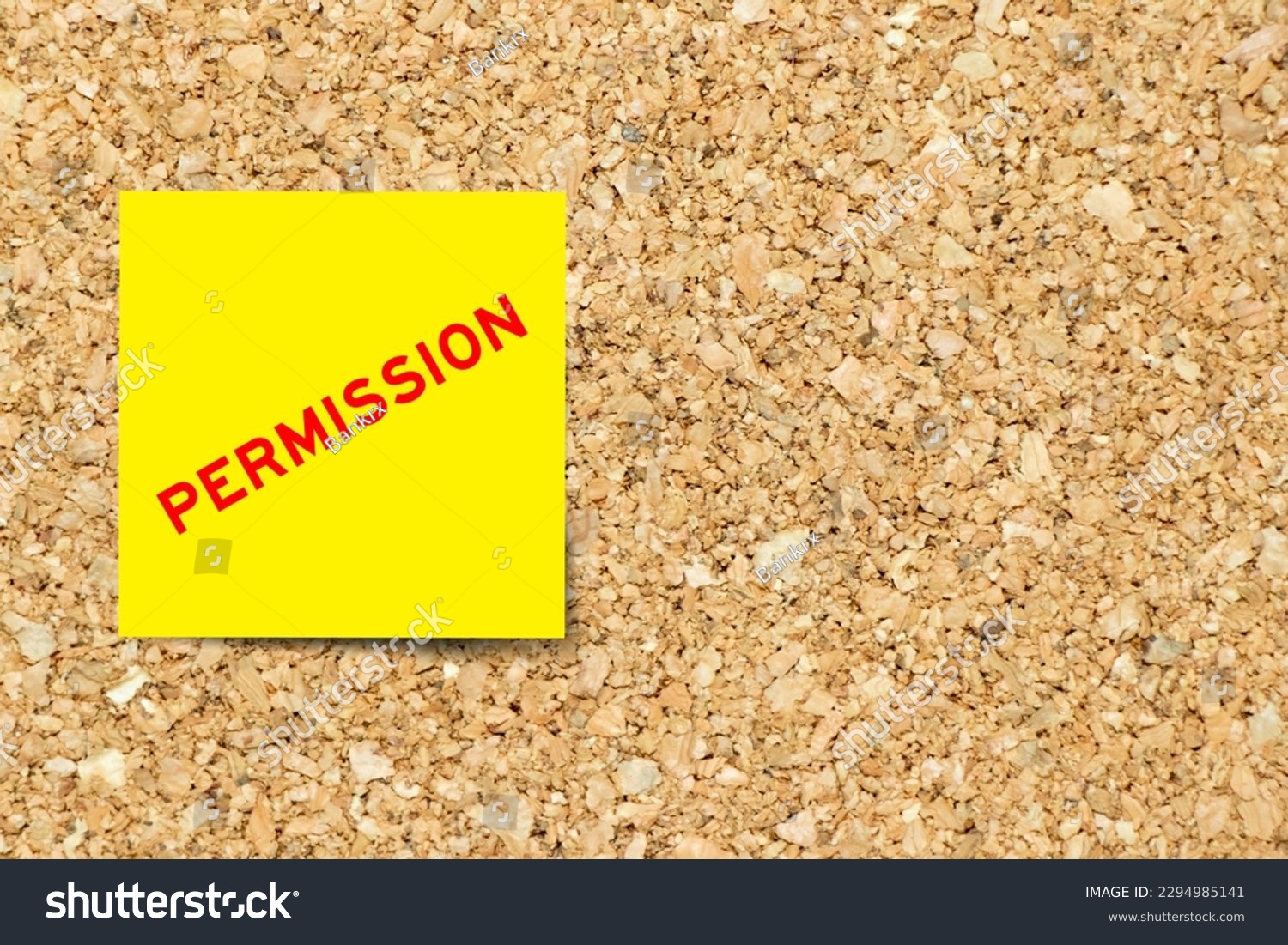 Yellow note paper with word permission on cork board background with copy space #2294985141