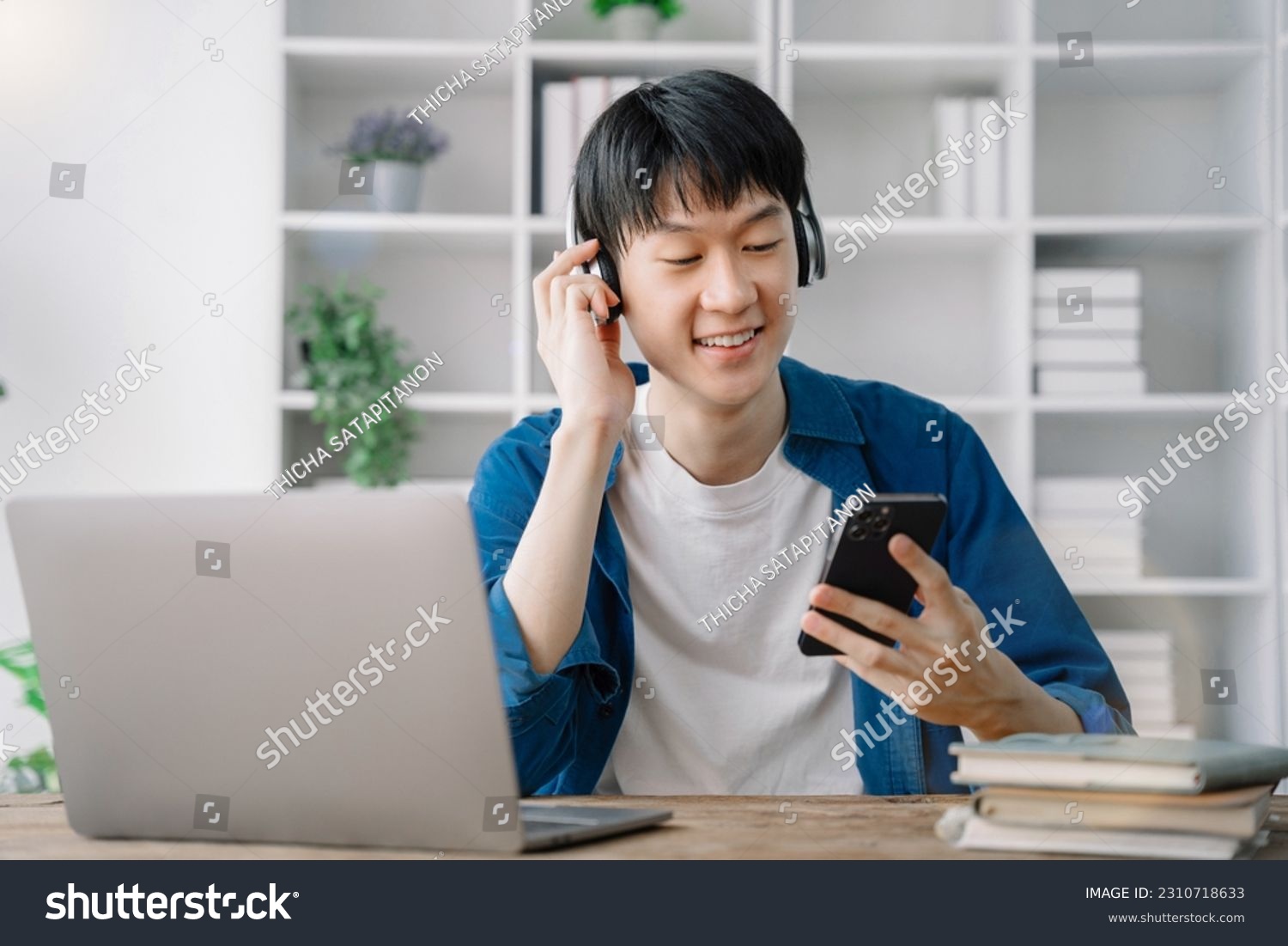 Asian young man wearing headphones to listen to music happy and relax. #2310718633
