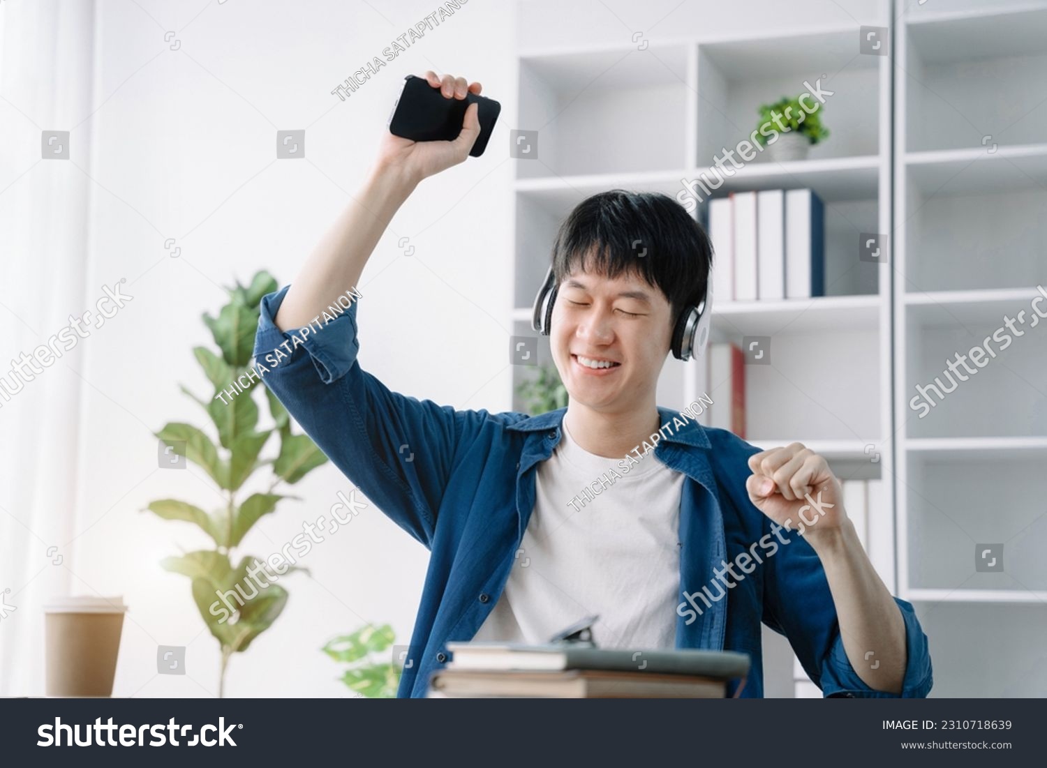 Asian young man wearing headphones to listen to music happy and relax. #2310718639