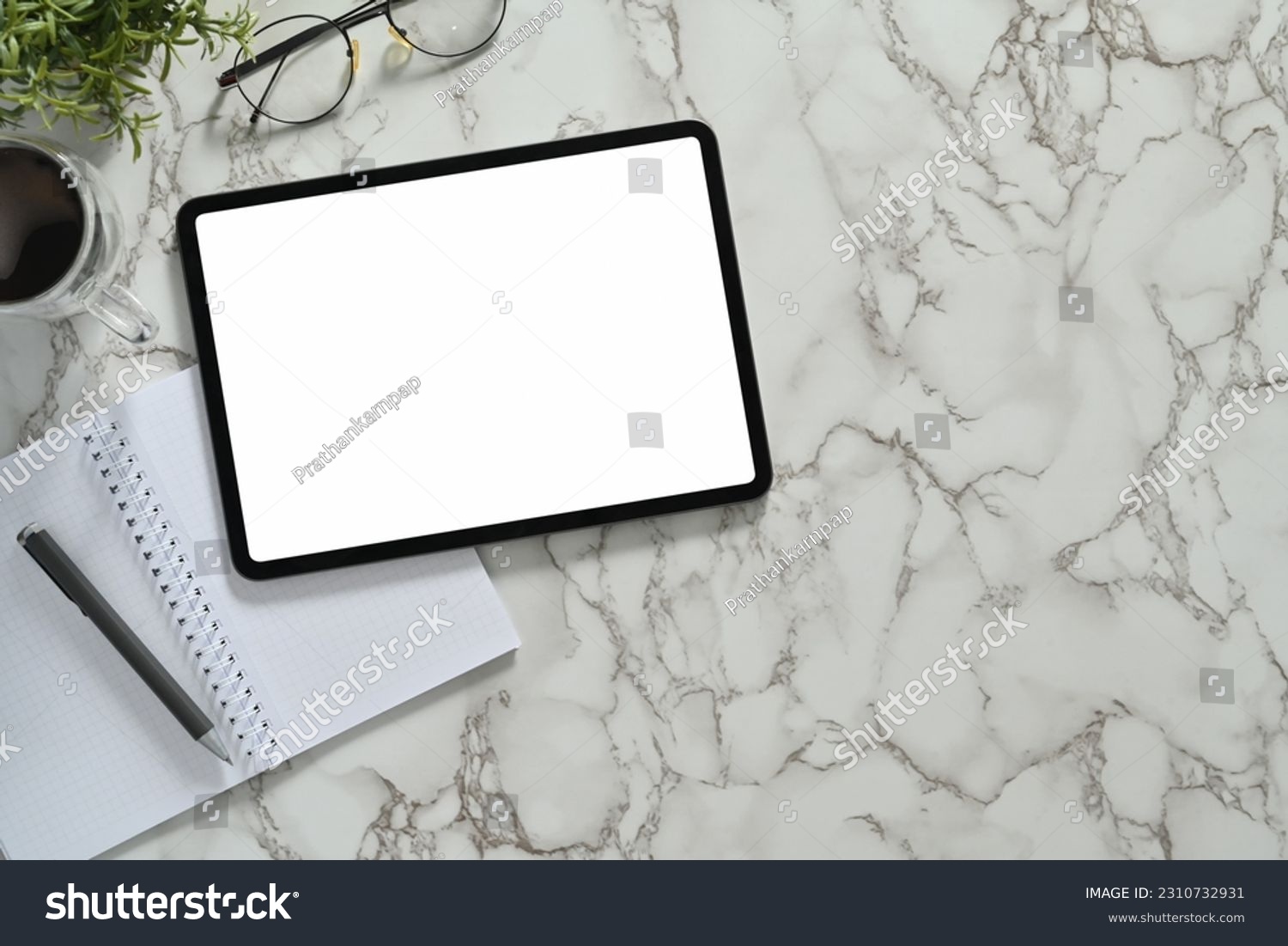 Top view of digital tablet with white empty screen, headphone and coffee cup on marble table #2310732931