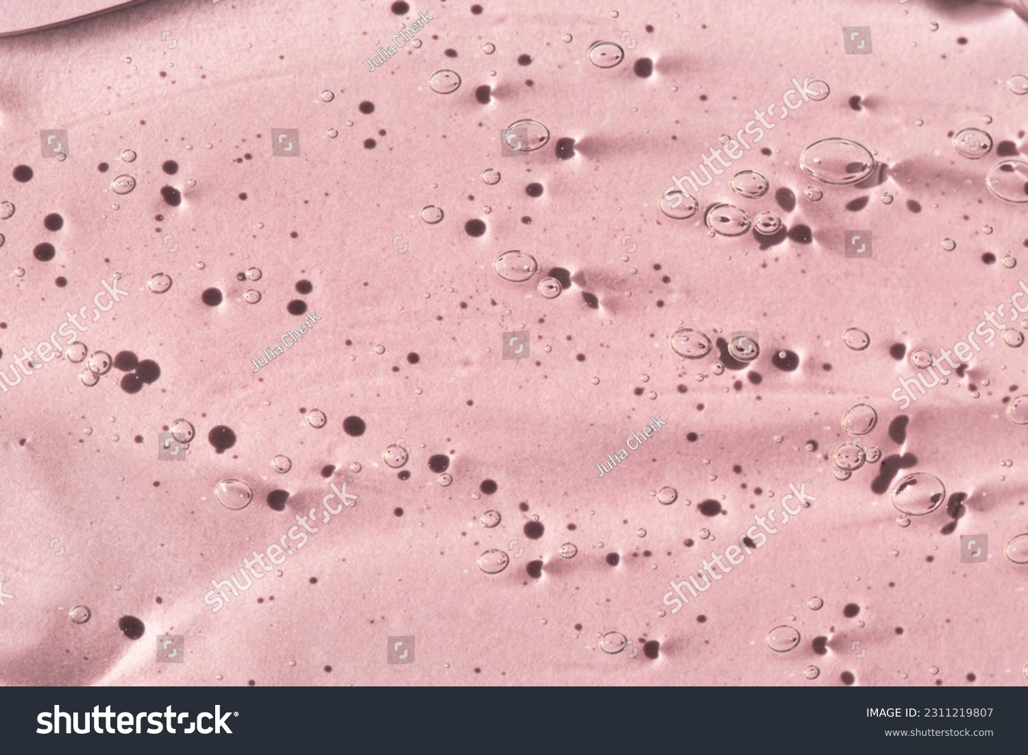 Transparent cosmetic texture of serum, skin gel on a pink background, macro top view. #2311219807