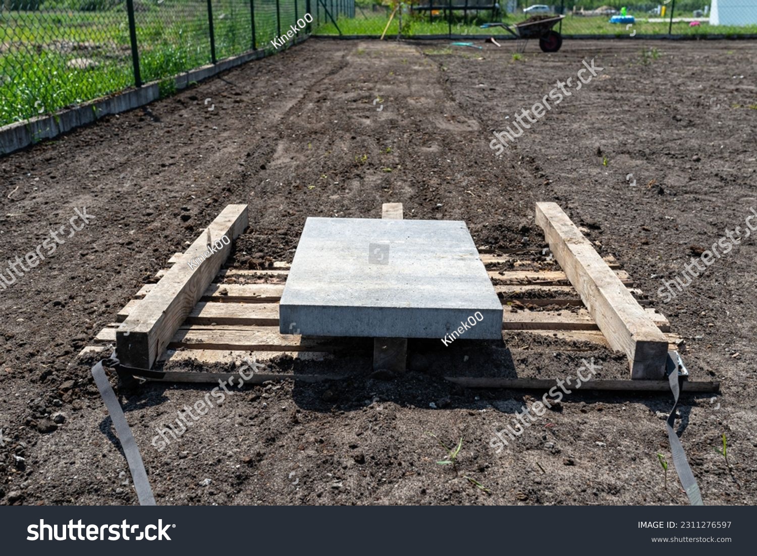 Leveling the chernozem in the yard with a pallet weighted with a concrete cube, preparing for sowing the lawn. #2311276597