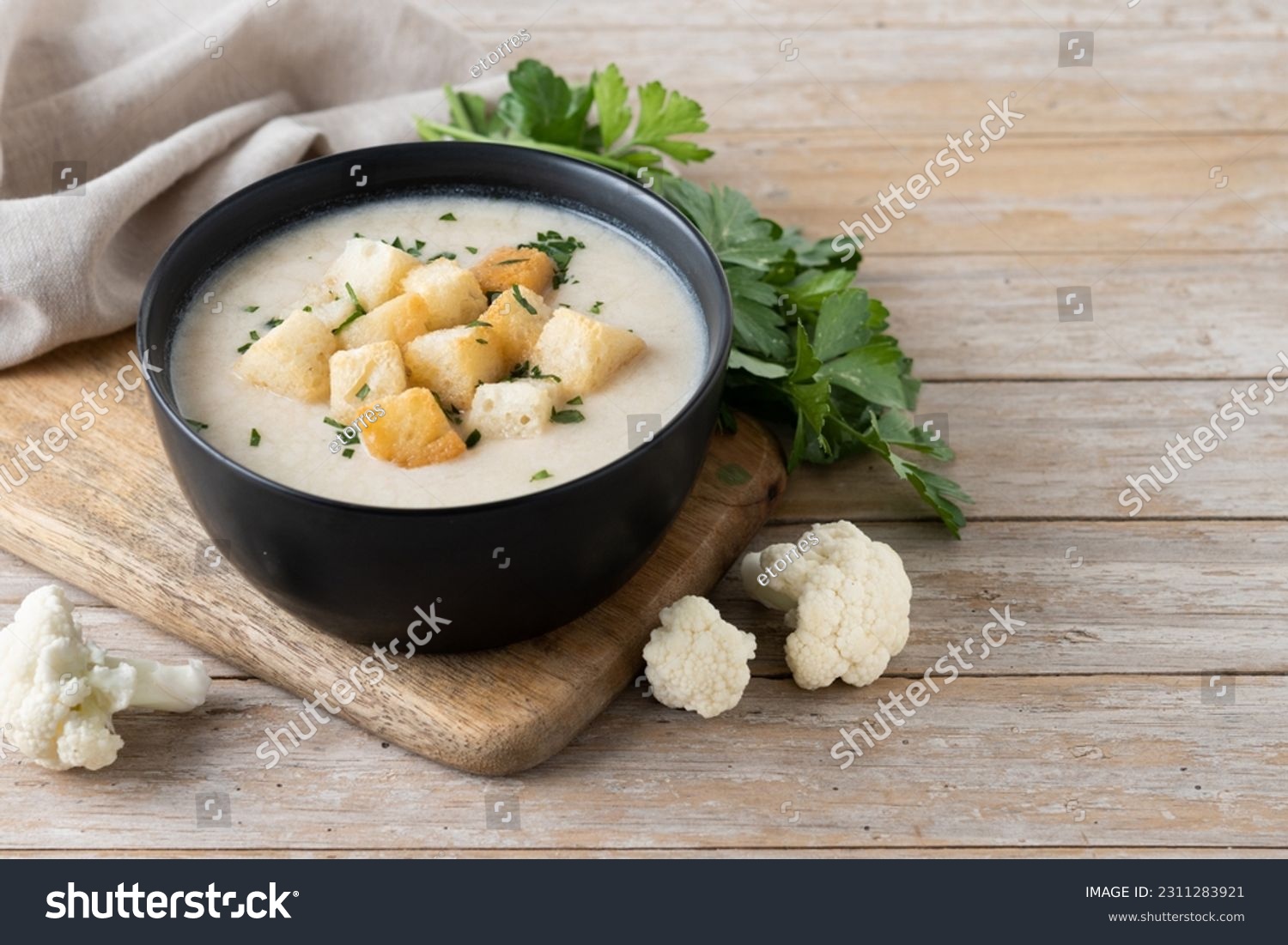 Cauliflower soup in a bowl on wooden table. Copy space #2311283921