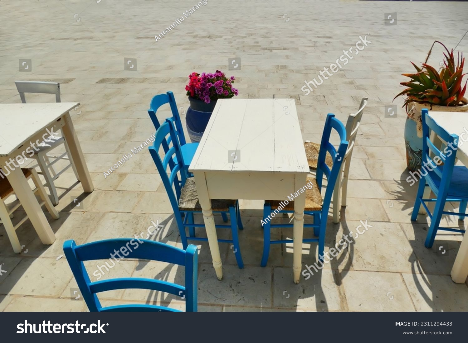 Deserted grunge style wooden table and chairs on sidewalk #2311294433
