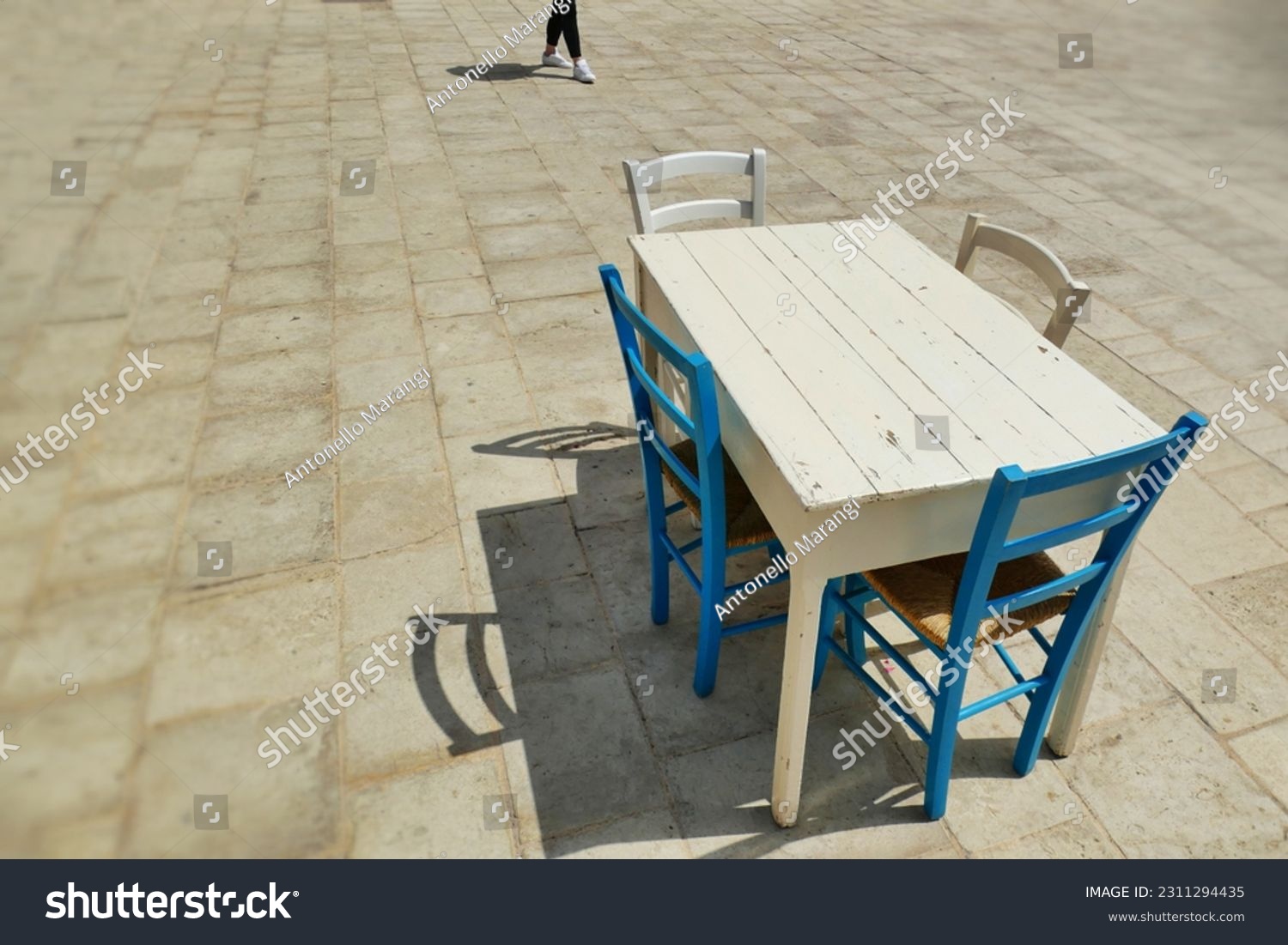 Deserted grunge style wooden table and chairs on sidewalk #2311294435