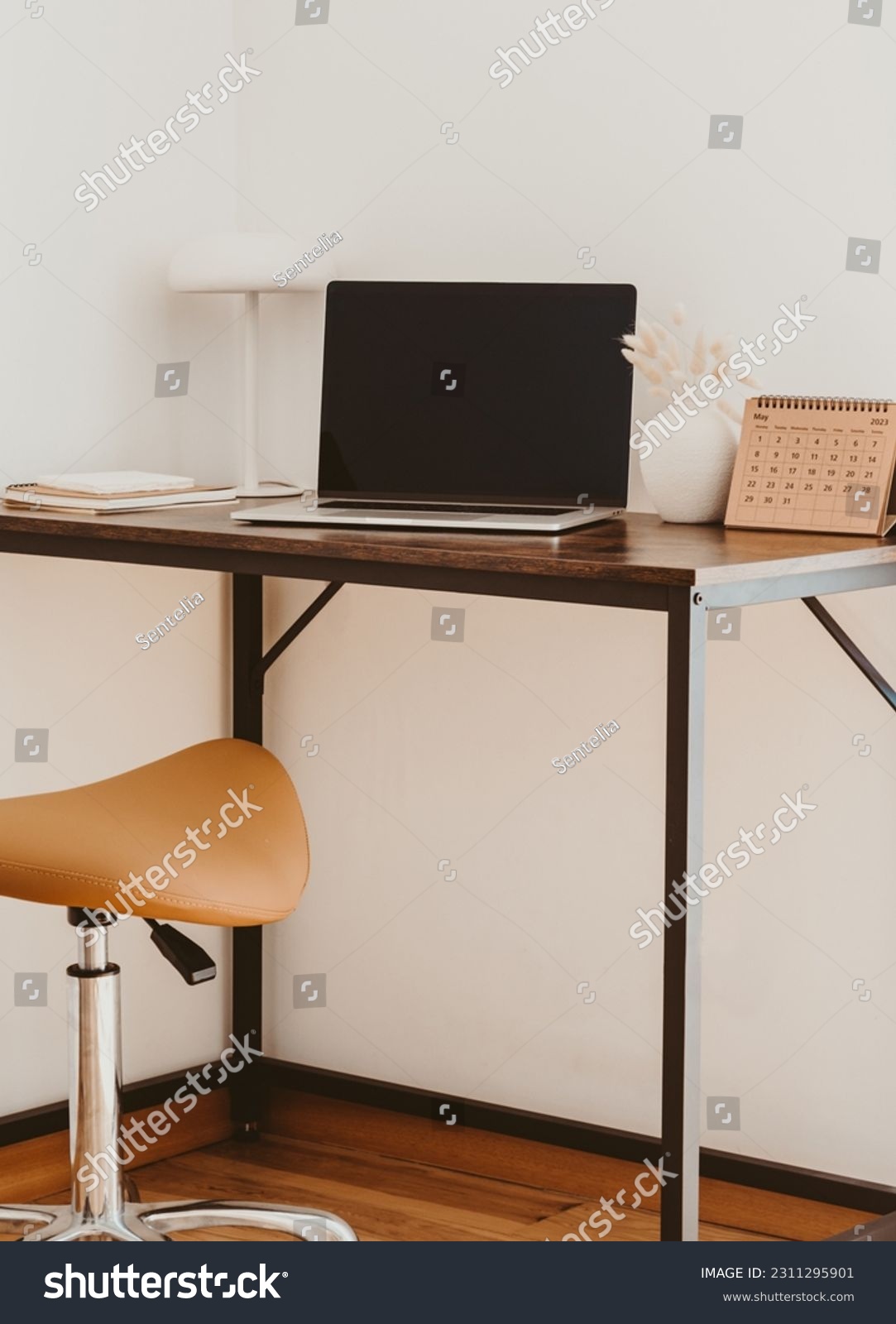 Stylish home office interior with laptop screen mockup, wooden table, plant, notes, saddle stool and elegant office accessories in designer apartment. #2311295901