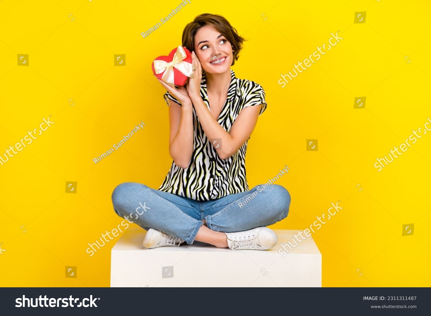 Full length photo of pretty thoughtful lady wear animal print shirt holding heart box looking empty space isolated yellow color background #2311311487