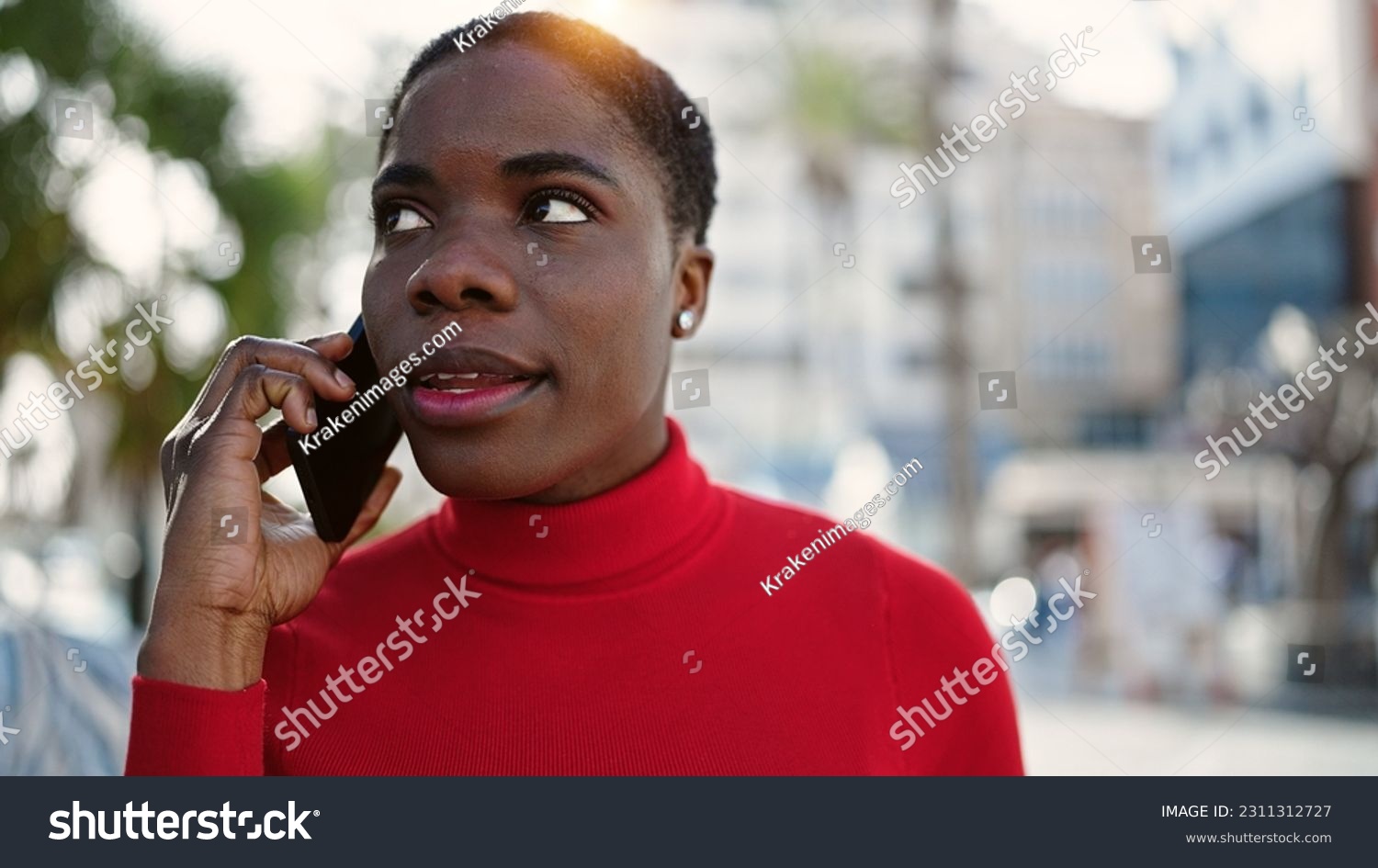 African american woman talking on smartphone with serious expression at street #2311312727