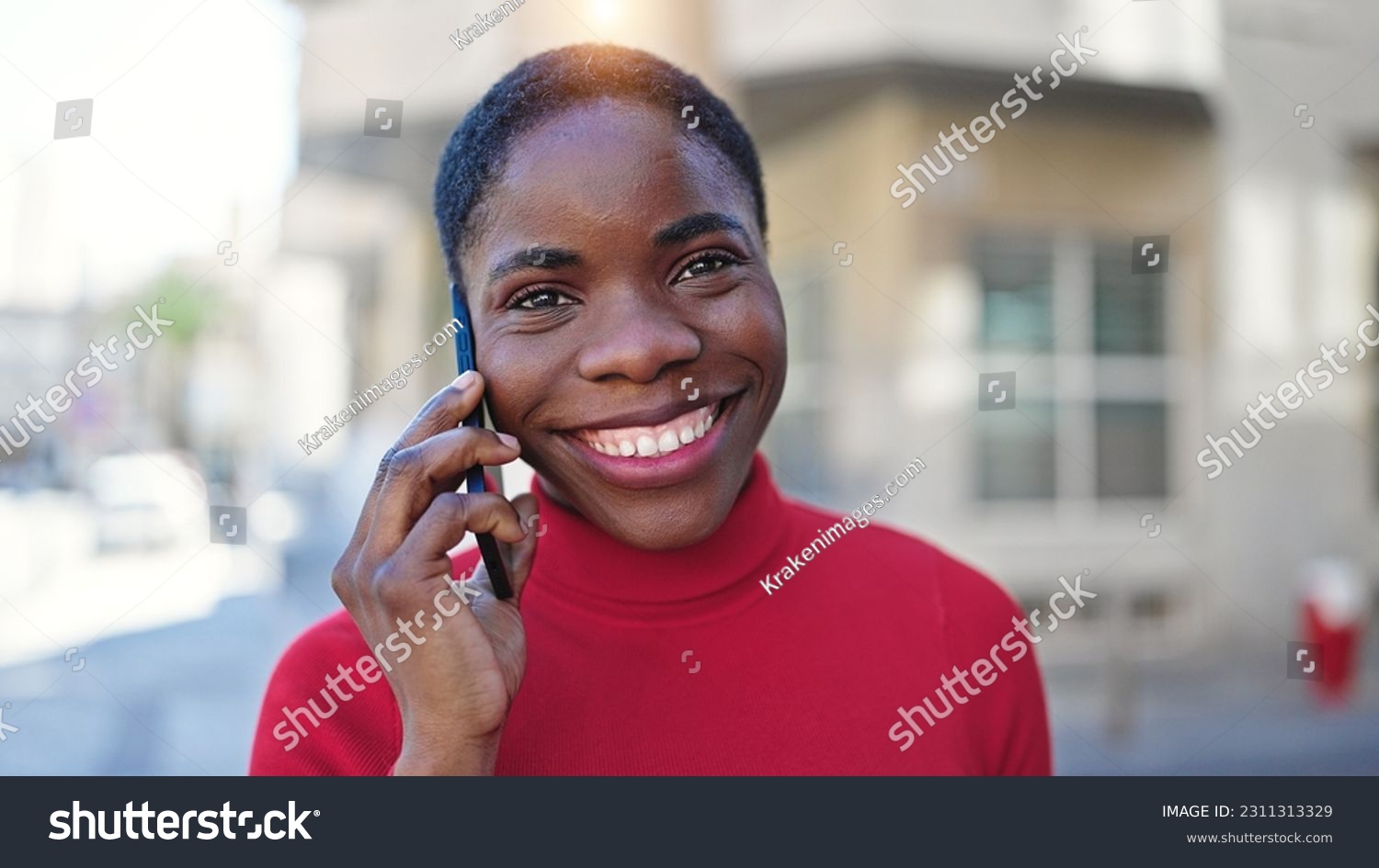African american woman talking on smartphone smiling at street #2311313329
