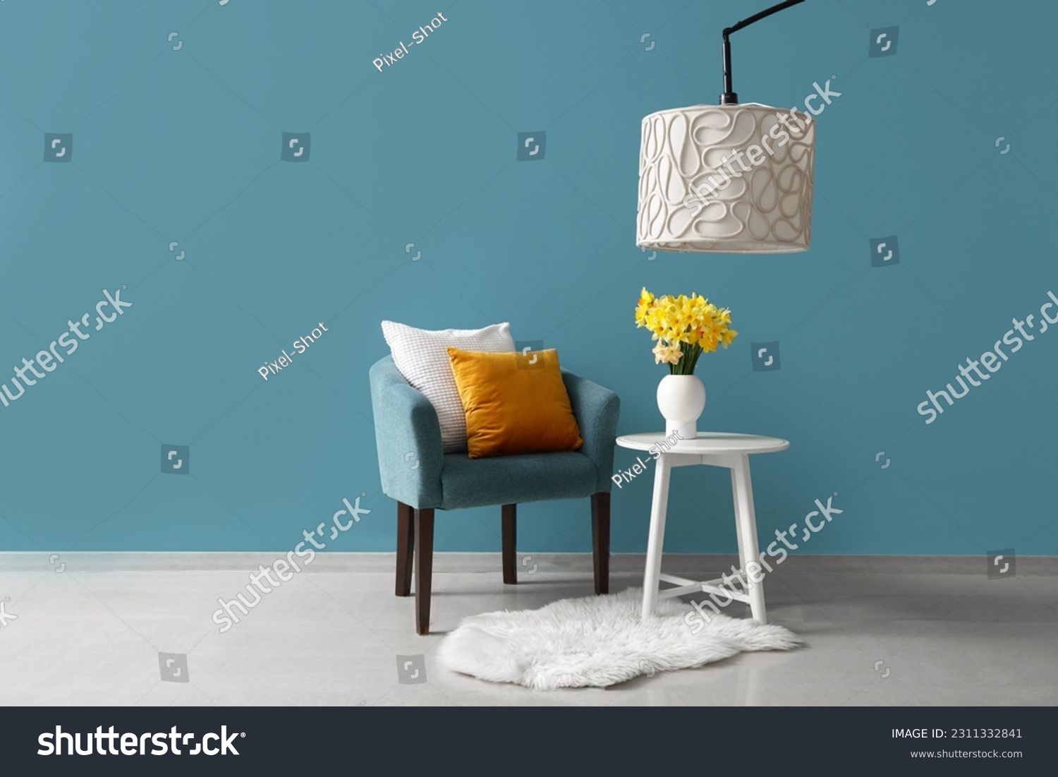 Cozy armchair with cushions and blooming narcissus flowers on coffee table near blue wall #2311332841