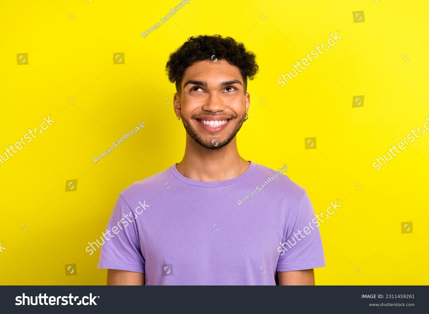 Photo of positive thoughtful guy dressed purple t-shirt looking up empty space isolated yellow color background #2311459261