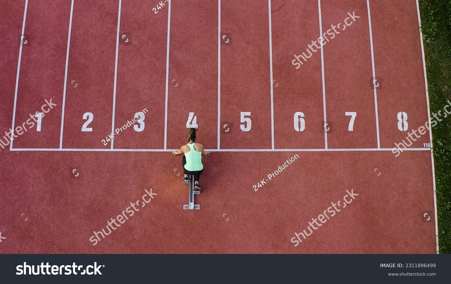 Caucasian female athlete alone on the athletic track, sprint running in line four, aerial directly above view. #2311896499