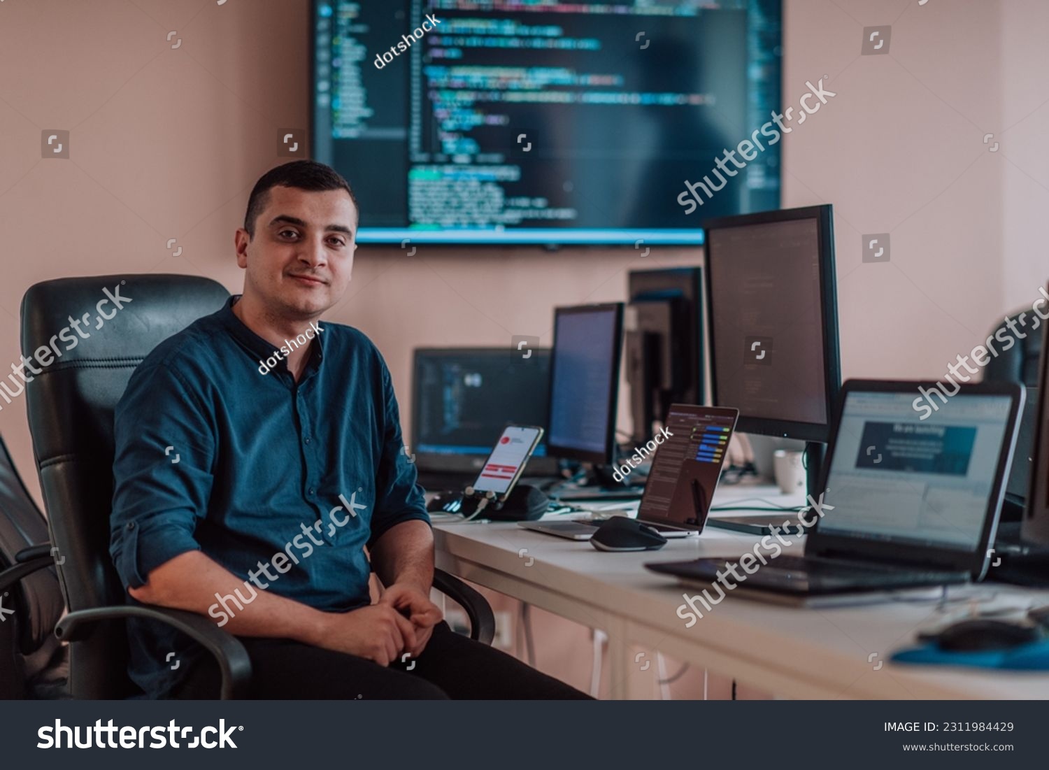 A programmer diligently testing smartphone applications while sitting in their office. #2311984429