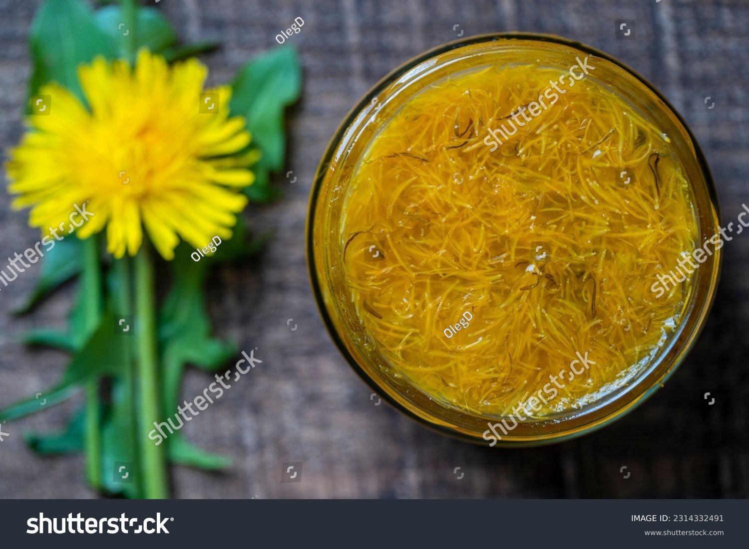 Sweet jam in glass jar jam from ripe yellow petals of dandelion flowers, orange, lemon and sugar, top view, close up. Dandelion famous medicinal plant #2314332491