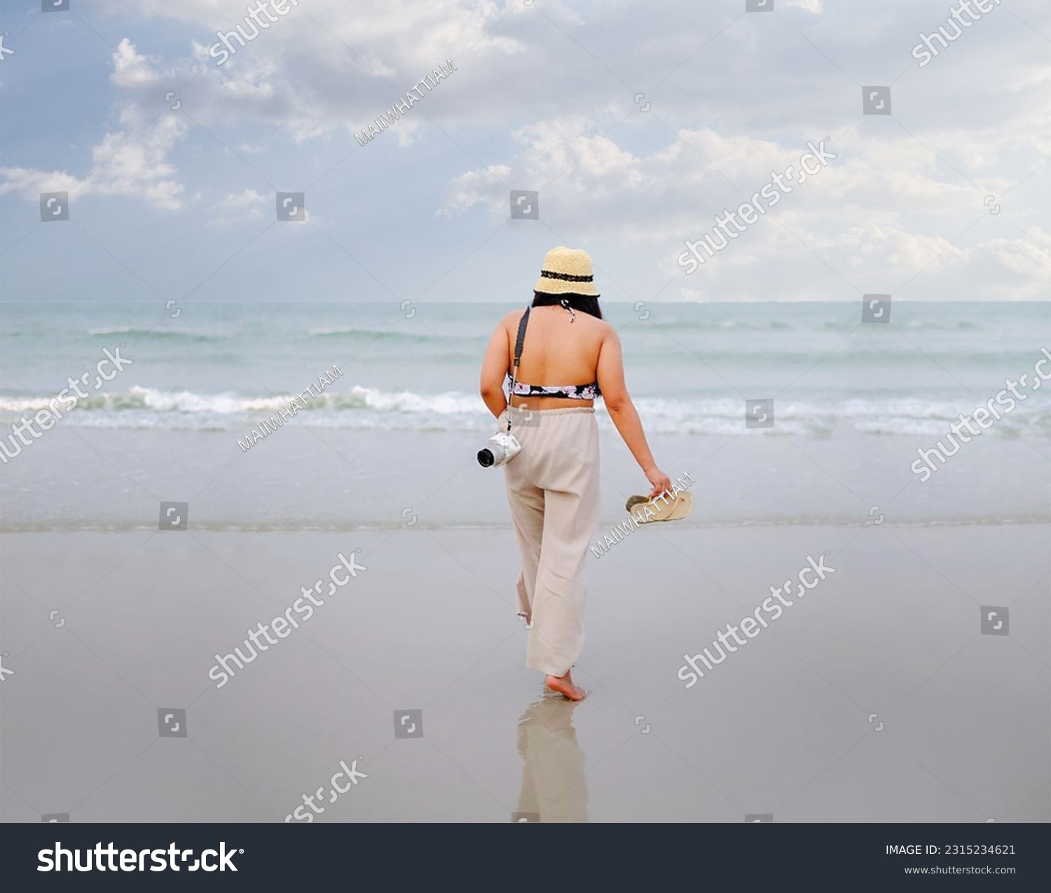A woman traveling alone, going to the beach, on vacation, carrying a camera, keeping the picture as a memory. relax and refresh #2315234621