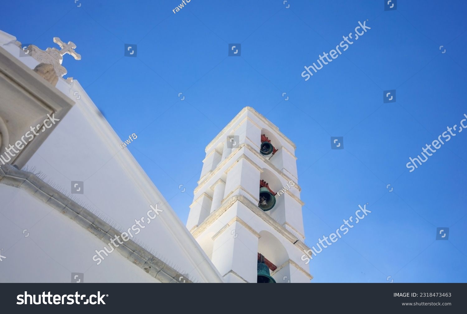Greece, Tinos island, Chora town religious destination Cyclades. Orthodox Church Belfry of Panagia Megalohari. Blue sky background. Under view #2318473463
