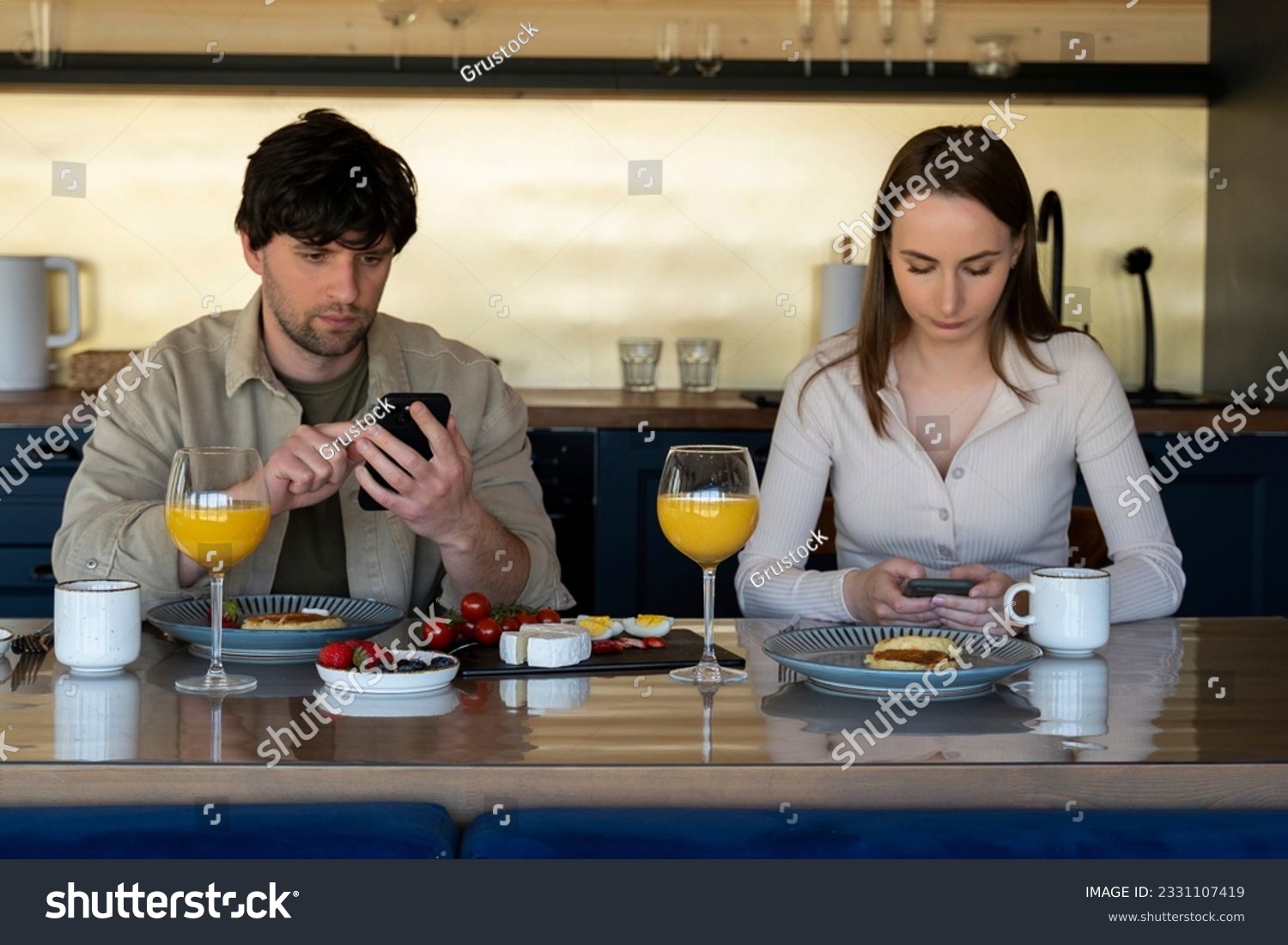 Young family drinks coffee and looks at smartphones. A young couple using smartphones ignore each other. use mobile apps or check social networks online. steam and technological concept #2331107419
