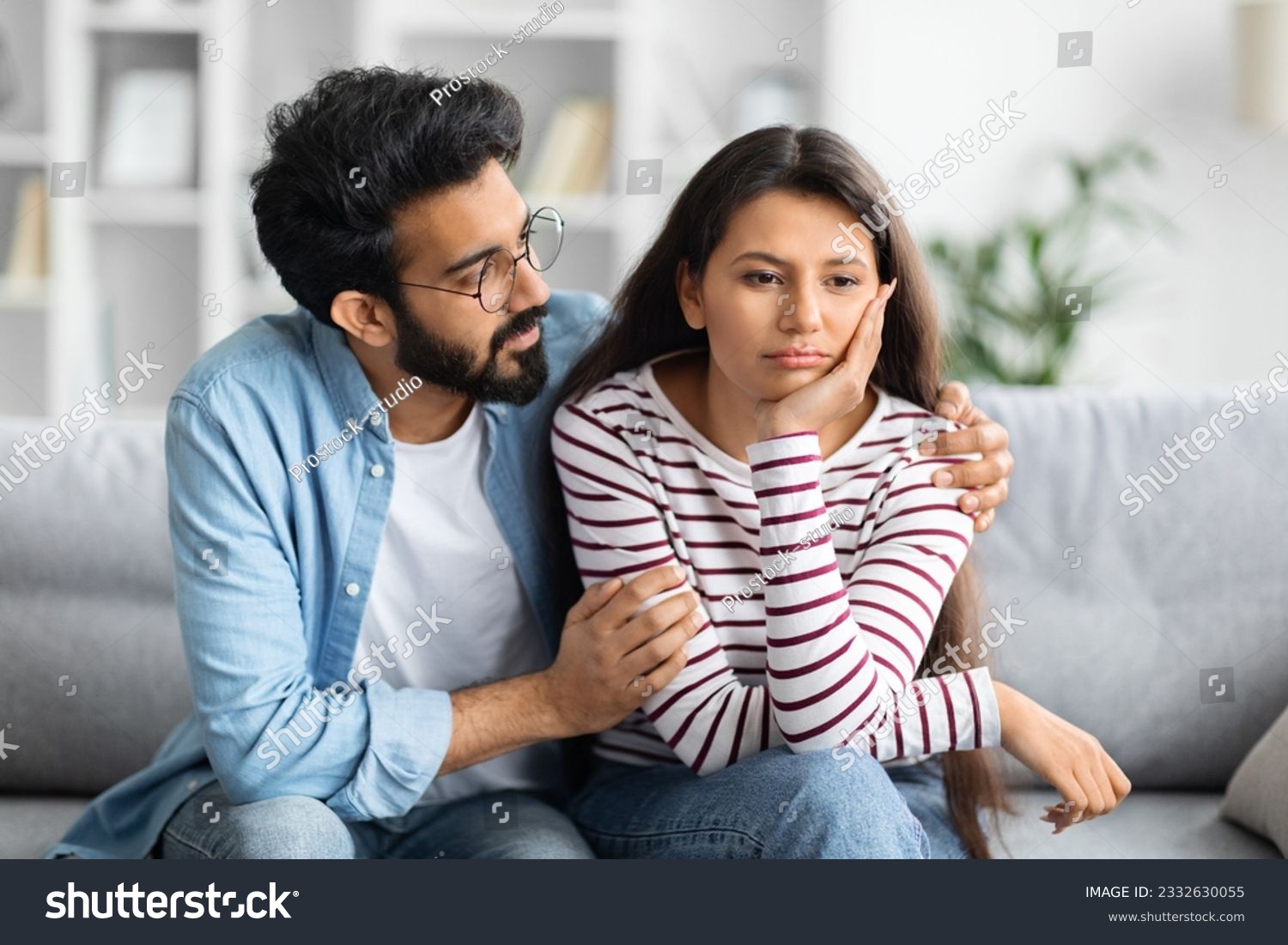Compassionate eastern husband giving comfort, support to upset wife, holding shoulders, speaking expressing empathy. Man feeling guilty, asking girlfriend to forgive. Relationship, compassion concept #2332630055