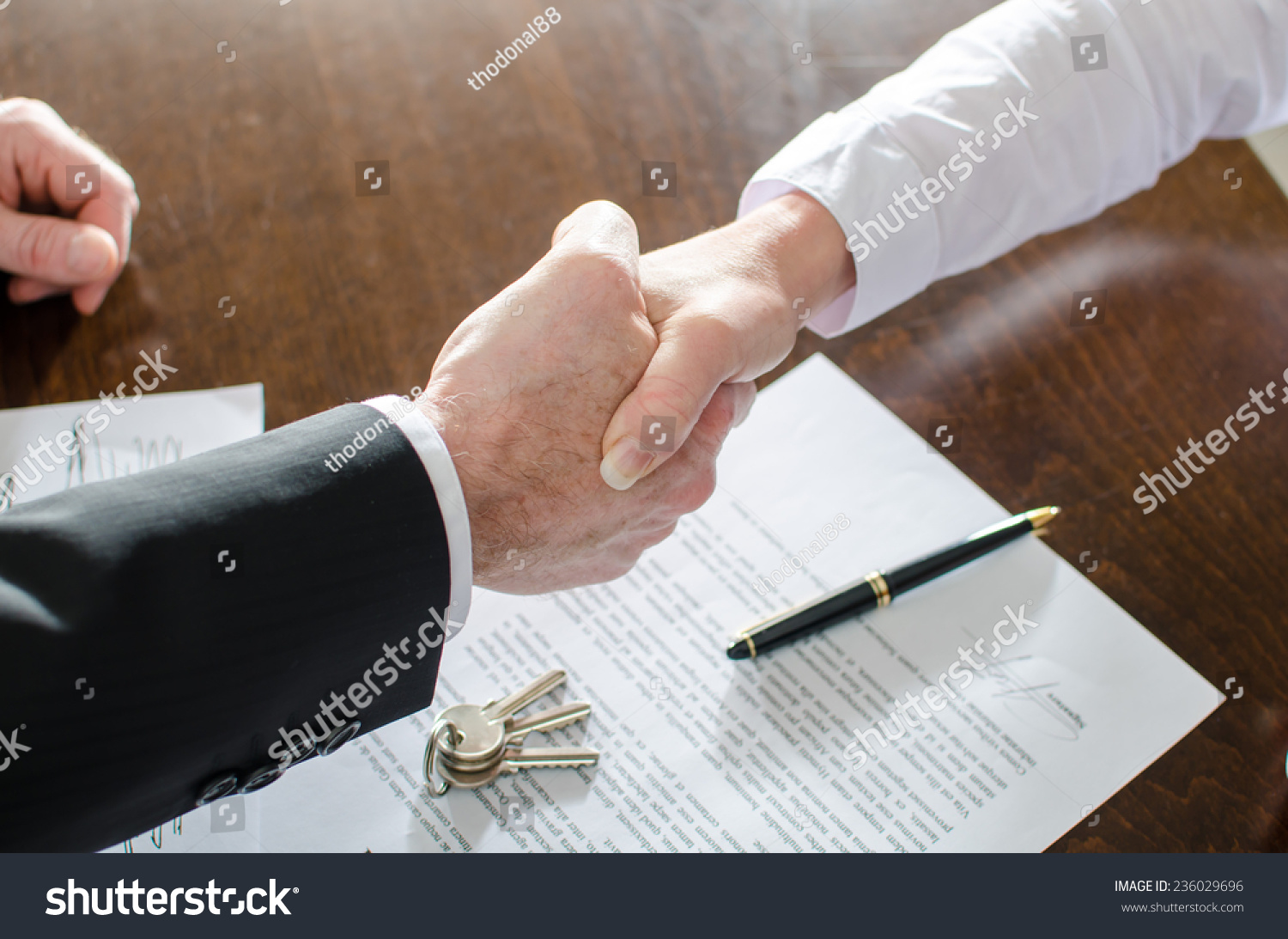 Estate agent shaking hands with his customer after contract signature #236029696