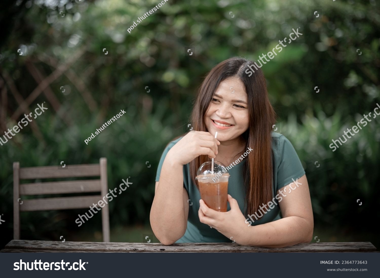 Asian young woman drinking green tea and thinking about something during coffee break at cafe #2364773643