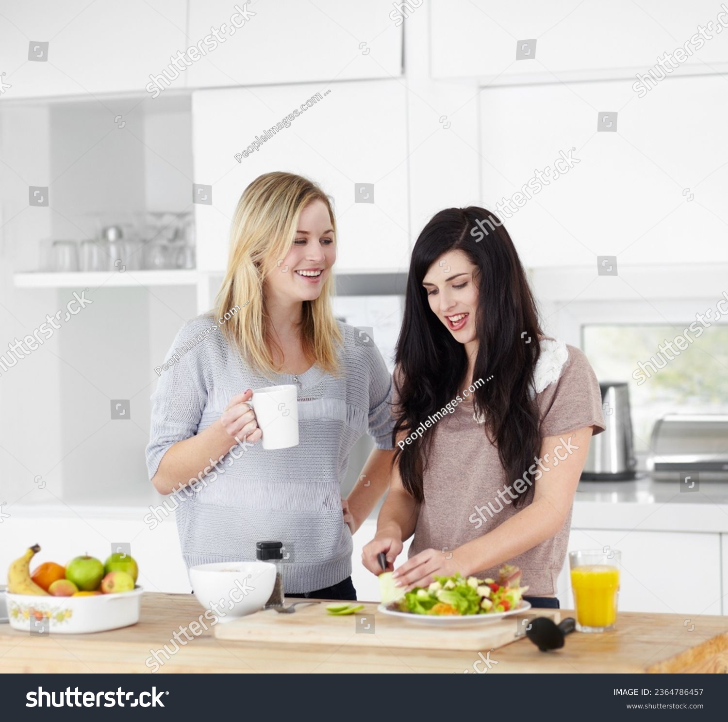 Kitchen, friends and vegan women with salad for healthy eating, meal and lunch together at home. Food, nutrition and happy female people smile with drink and vegetables for diet, wellness and detox #2364786457