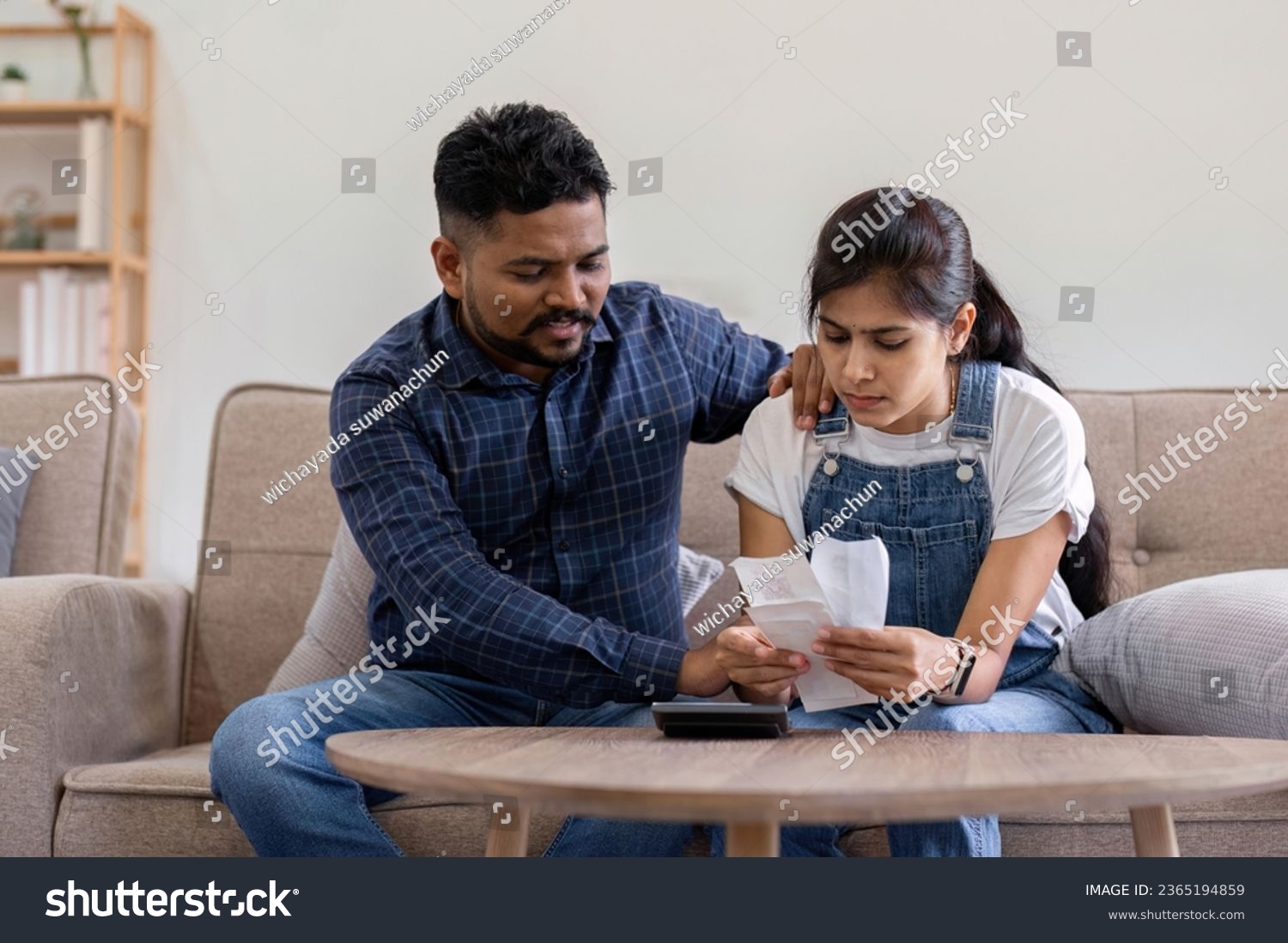 Young couple stressing about bills and invoices in living room Increased expenses cause stress. #2365194859