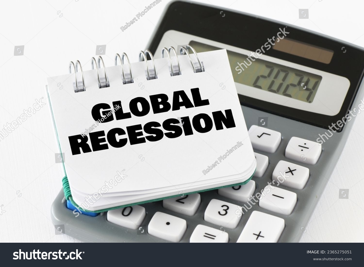GLOBAL RECESSION words in a notebook on a calculator. The concept of economic crisis #2365275051