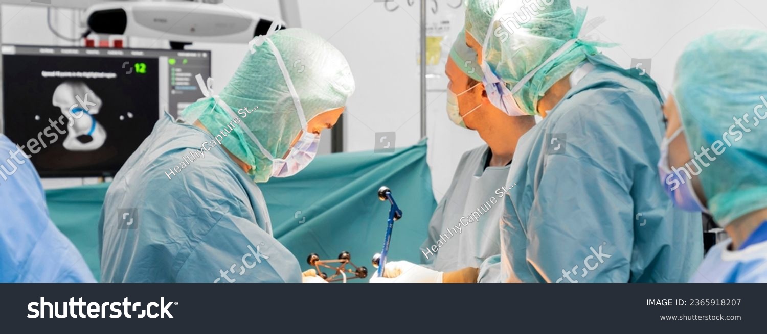 Team of doctor perform total hip arthroplasty replacement surgery in osteoarthritis patient inside the operating room. robot-assisted - robotic hip and knee replacement surgery #2365918207