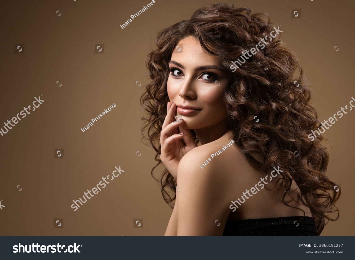 Beauty Model with Curly brown Hair. Young Woman with Long Wavy Hairstyle over Dark beige. Beautiful Girl with smooth Skin natural Makeup #2366191277