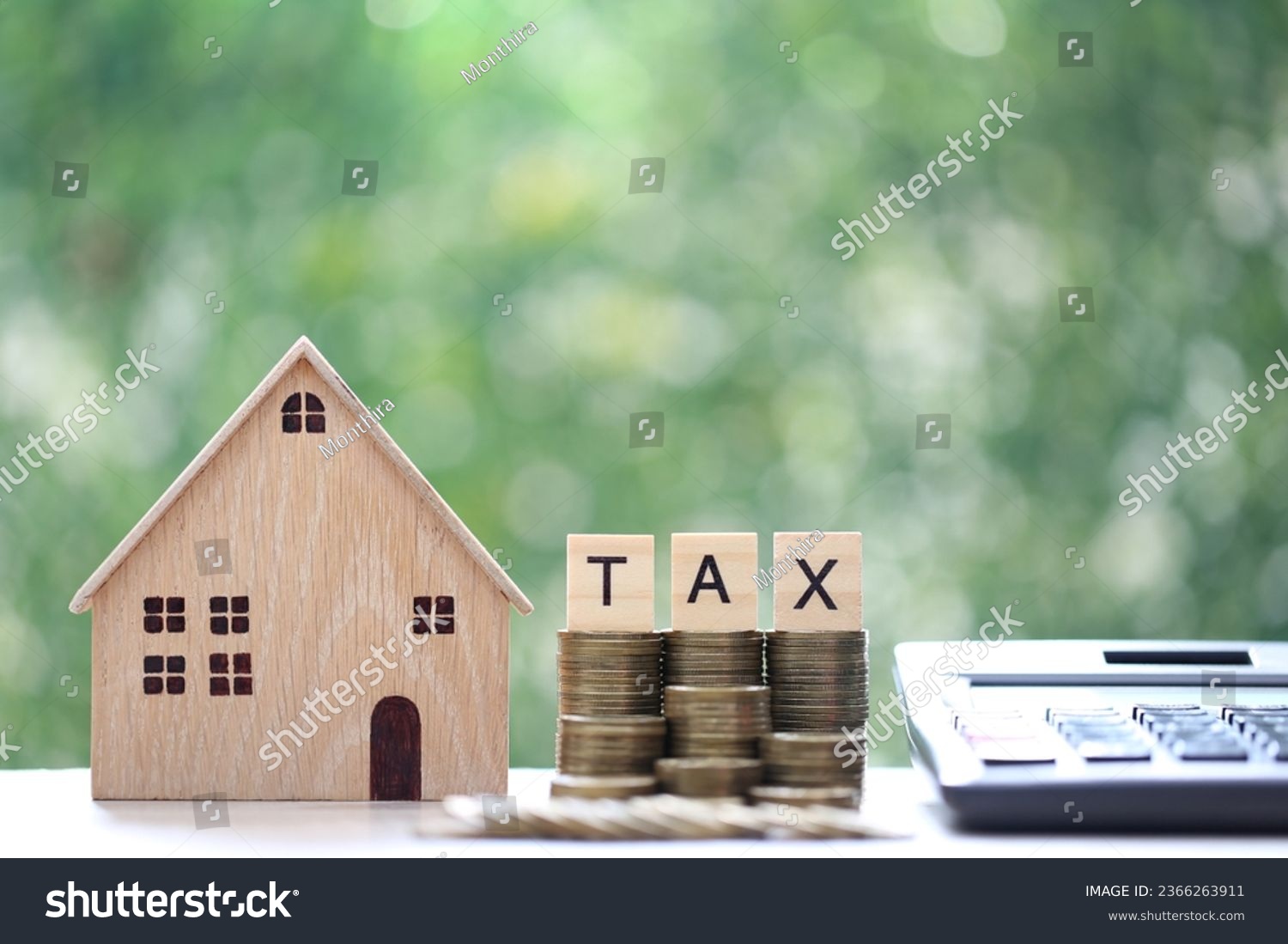 Tax concept,Model house with stack of coins money and tax word on green background,Business investment and Property tax concept #2366263911