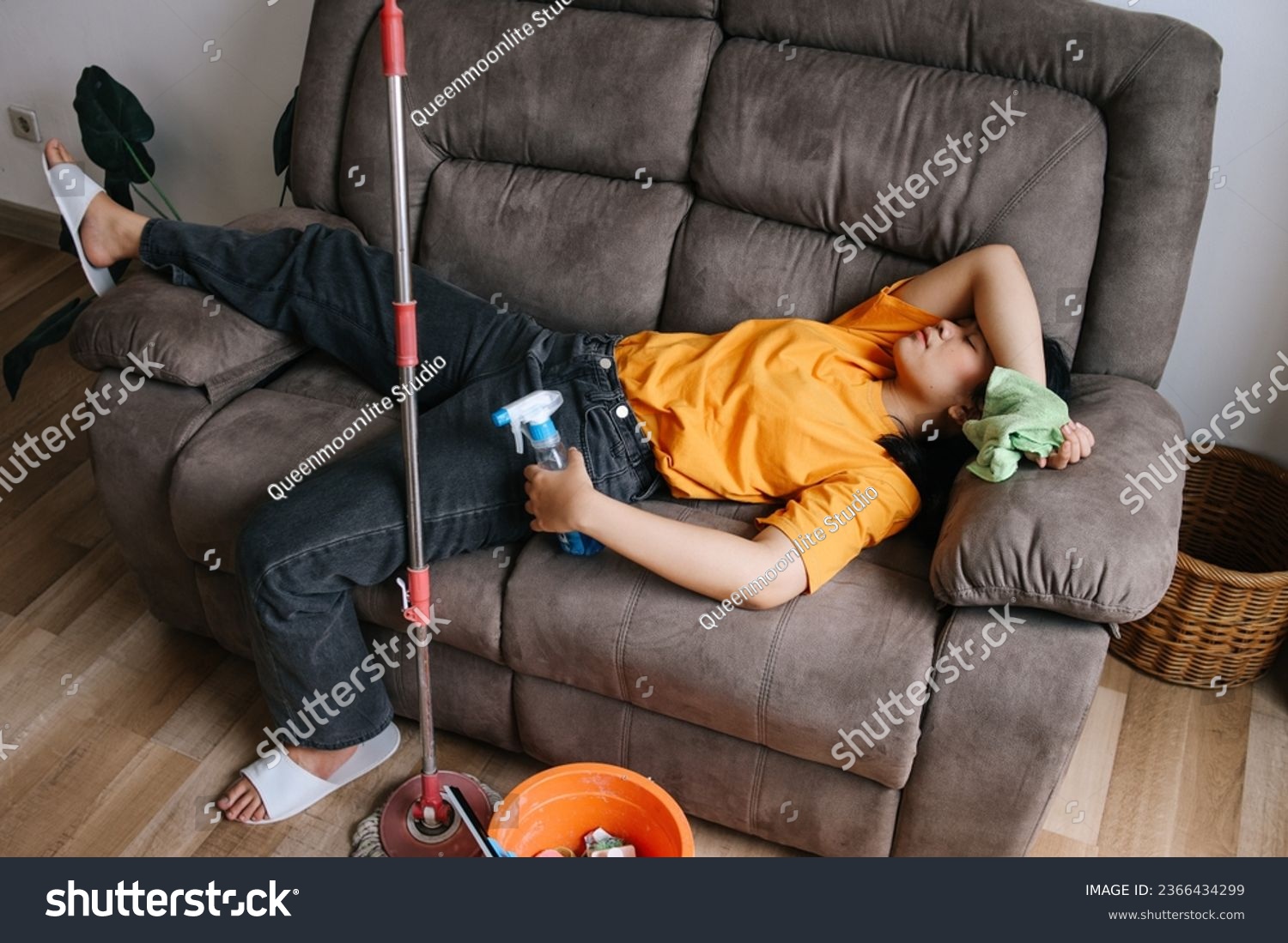 Top view of exhausted woman sleeping on couch during cleaning house #2366434299