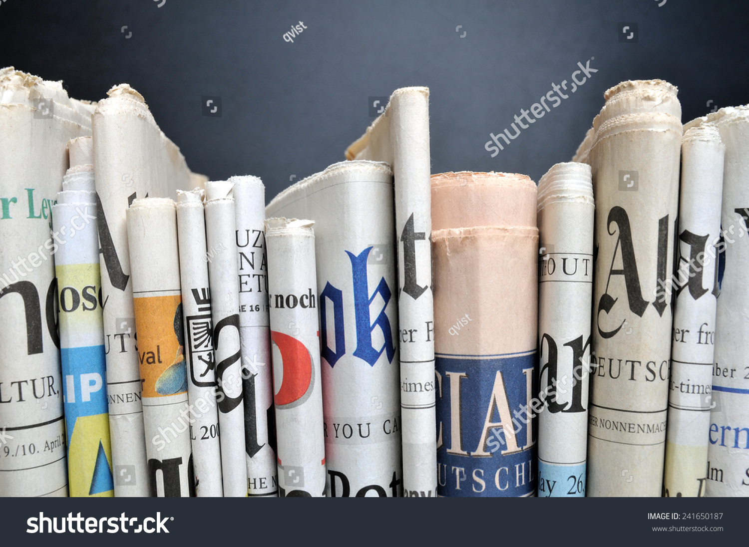 News - Folded newspapers in front of black wall #241650187