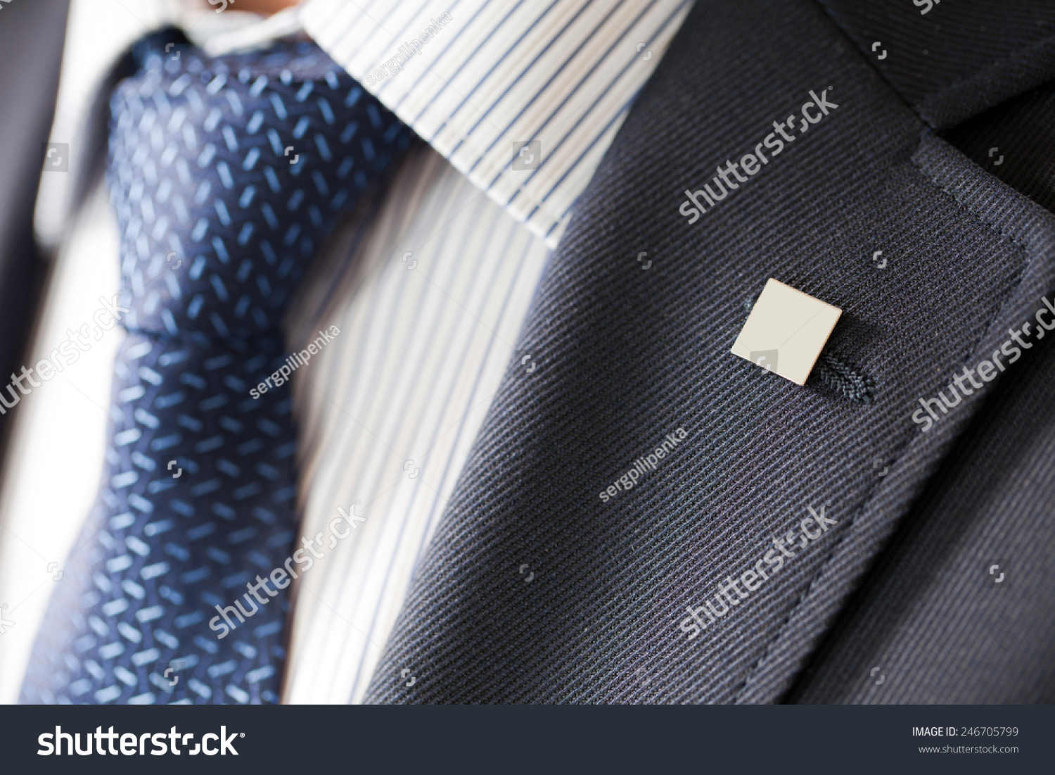 badge on the lapel of his jacket men's shirt with a blue tie #246705799