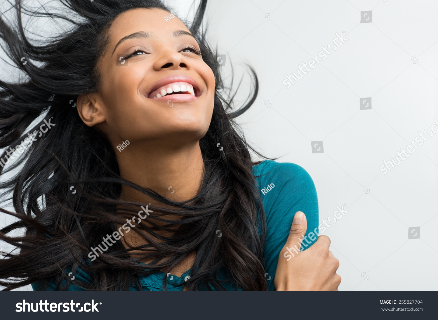 Closeup of smiling young woman with hair in the wind #255827704