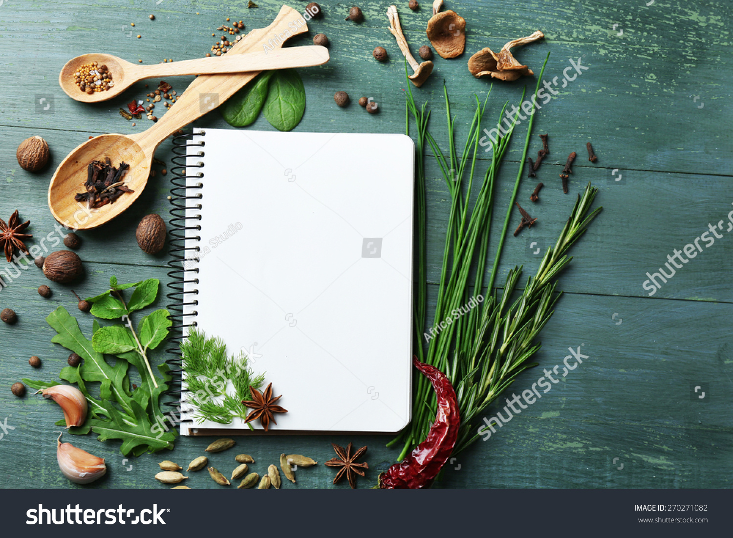 Open recipe book with fresh herbs and spices on wooden background #270271082