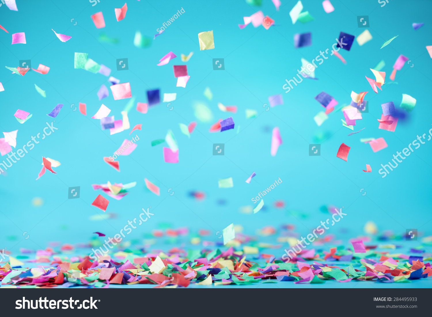 Colored confetti flying on blue background #284495933