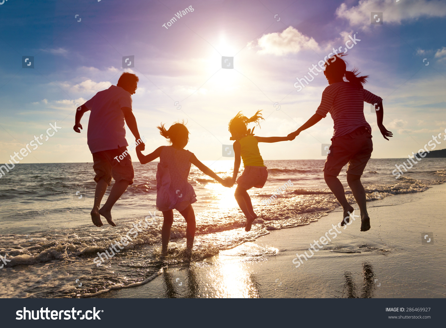happy family jumping together on the beach #286469927