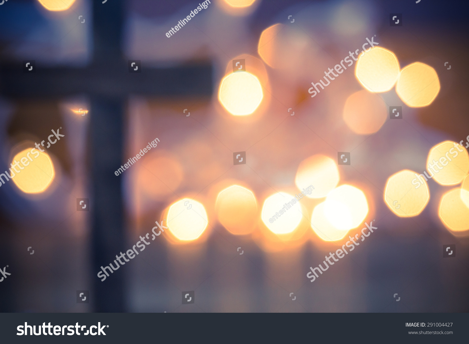 Wooden Christian Cross out of focus with a soft bokeh lights background #291004427