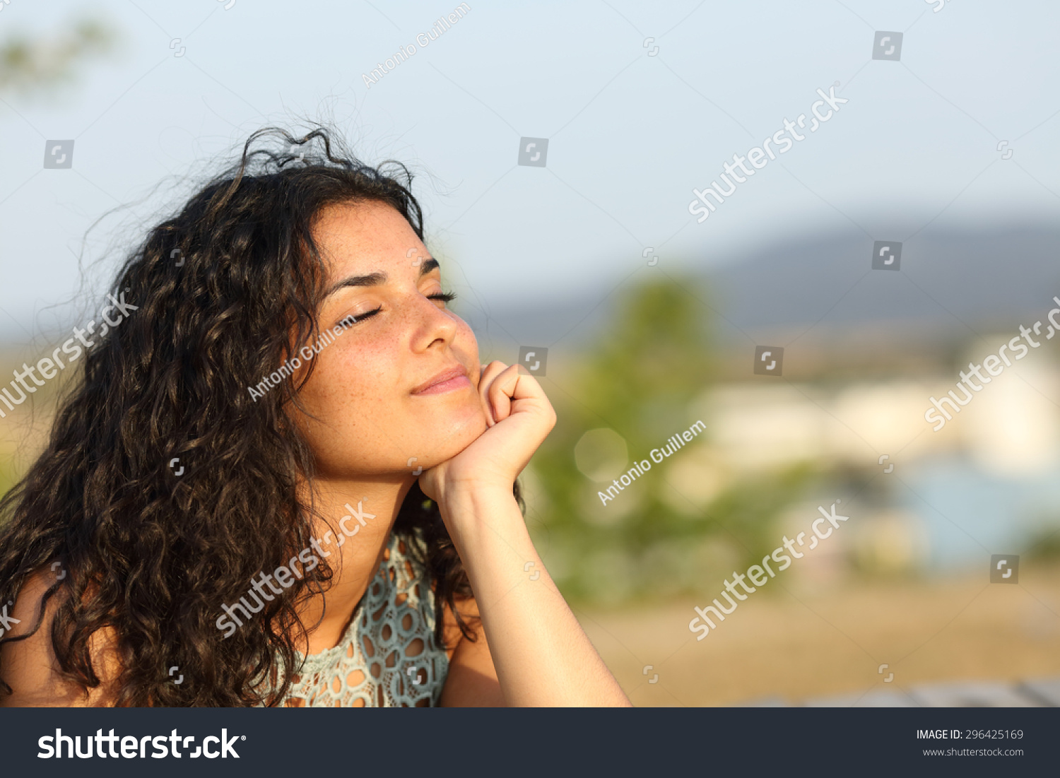 Woman relaxing and enjoying the sun in a warmth park at sunset #296425169