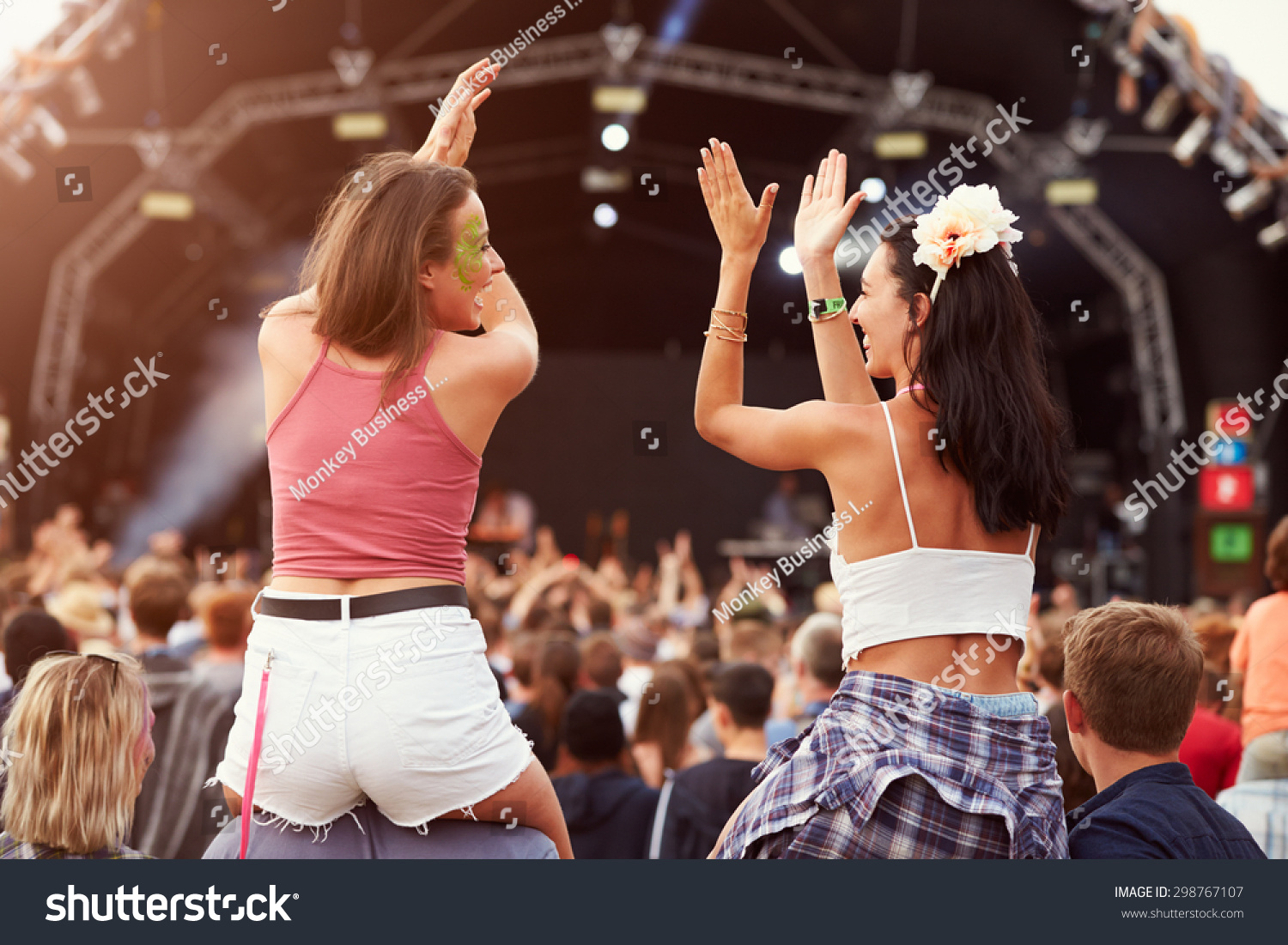 Two girls on shoulders in the crowd at a music festival #298767107