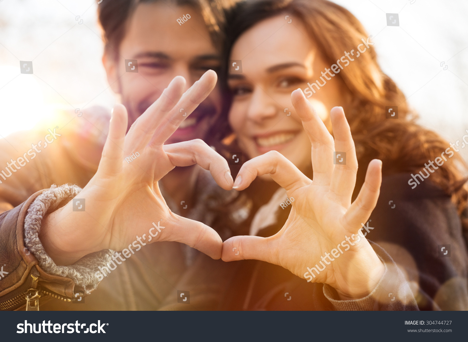 Closeup of couple making heart shape with hands #304744727
