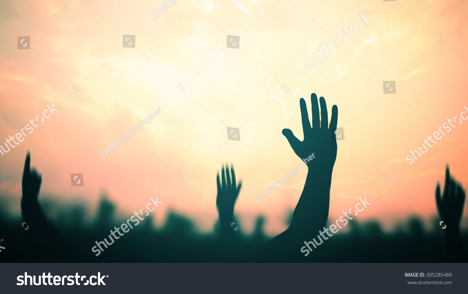 International migrants day concept: Silhouette many people raised hands over autumn sunset background #305285489