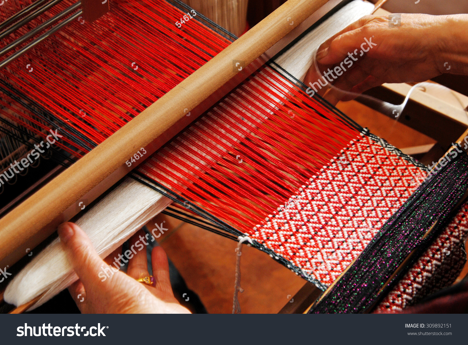 A traditional hand-weaving loom being used to make cloth  #309892151